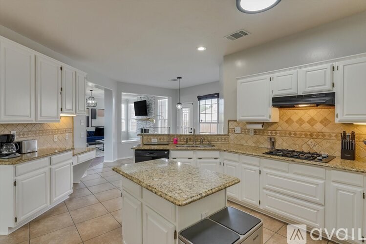 A kitchen with white cabinets and granite countertops.
