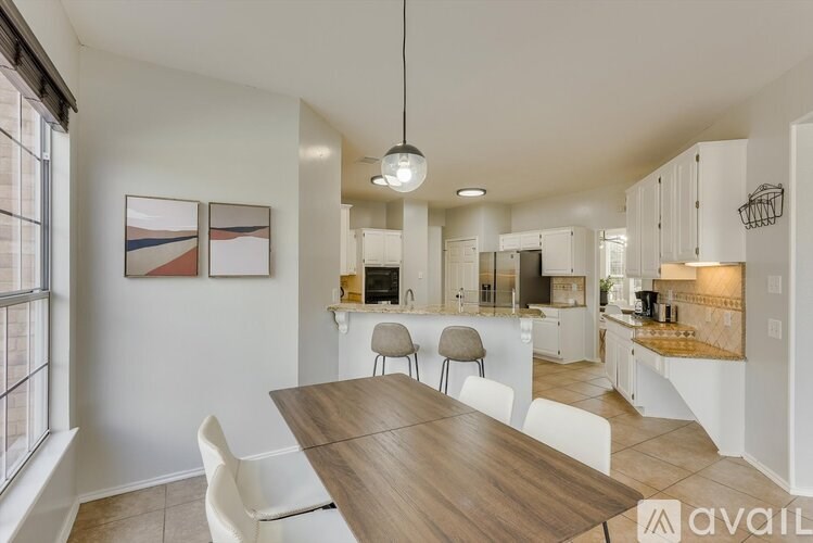A modern kitchen with a dining table and chairs.