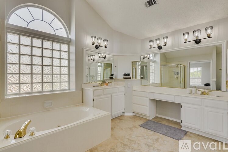 A bathroom with a large tub and double sinks.
