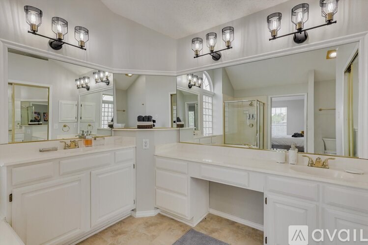 A bathroom with a large mirror and lights above it.