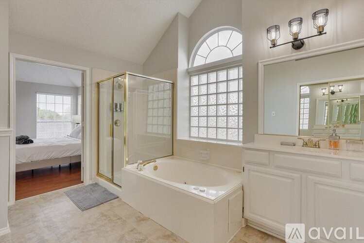 A bathroom with a tub, sink, and mirror.