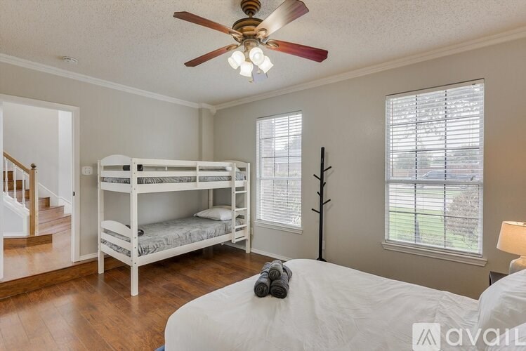A bedroom with a bunk bed and a ceiling fan.