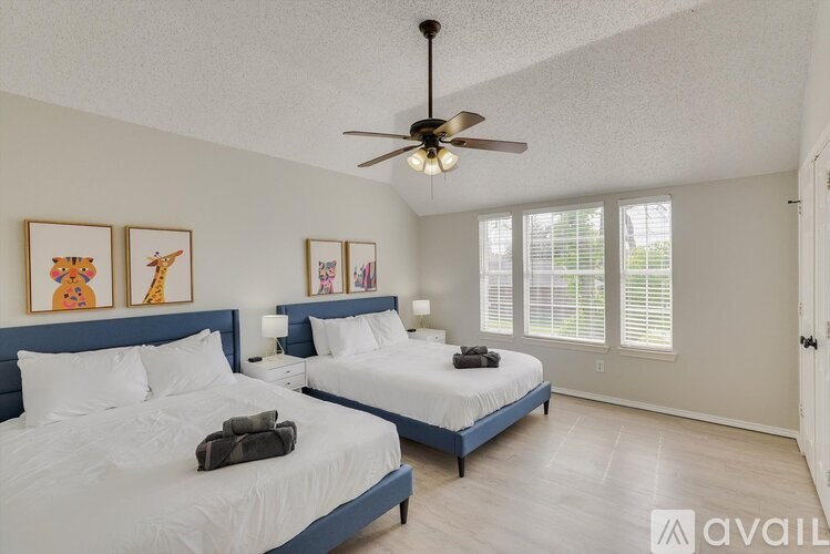A bedroom with two beds and a ceiling fan.