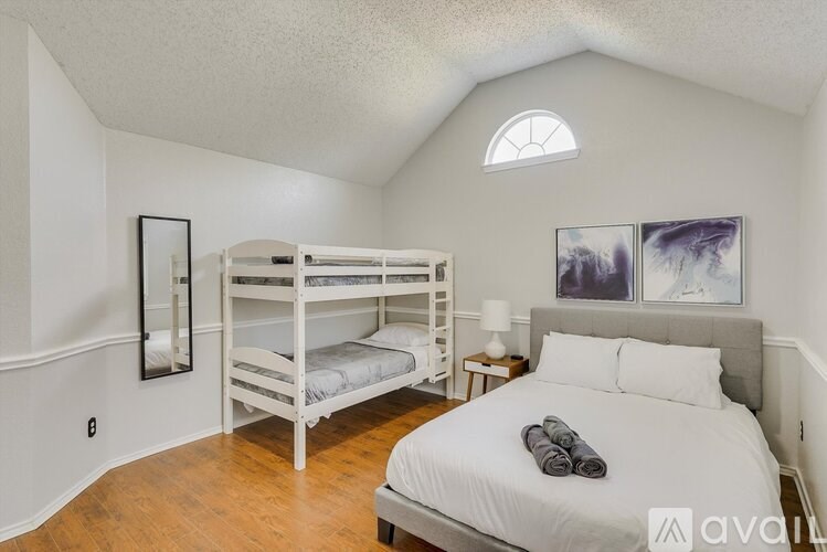 A bedroom with a white bed and a bunk bed.