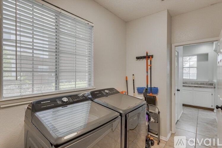 A kitchen with a dishwasher and a window with blinds.