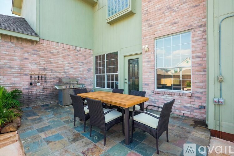 A patio with a table and chairs is set up outside a house.