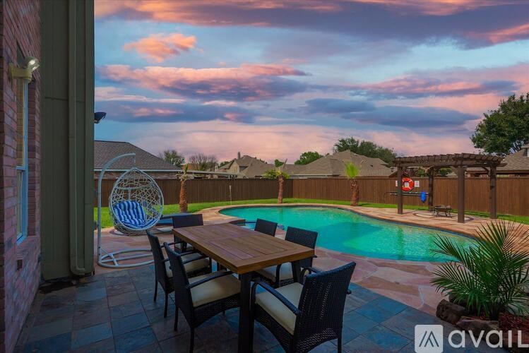 A backyard with a pool and a dining table.
