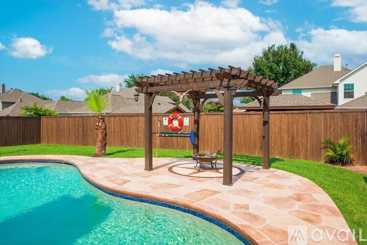 A pool with a pergola and a lifeguard sign.