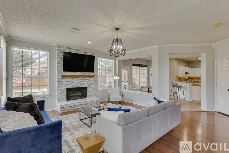 A living room with a blue couch and a fireplace.