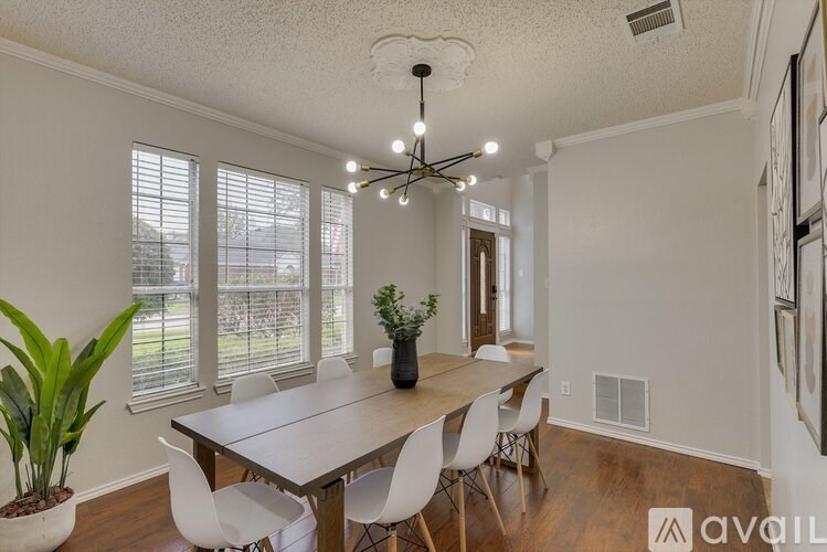A dining room with a white table and chairs.