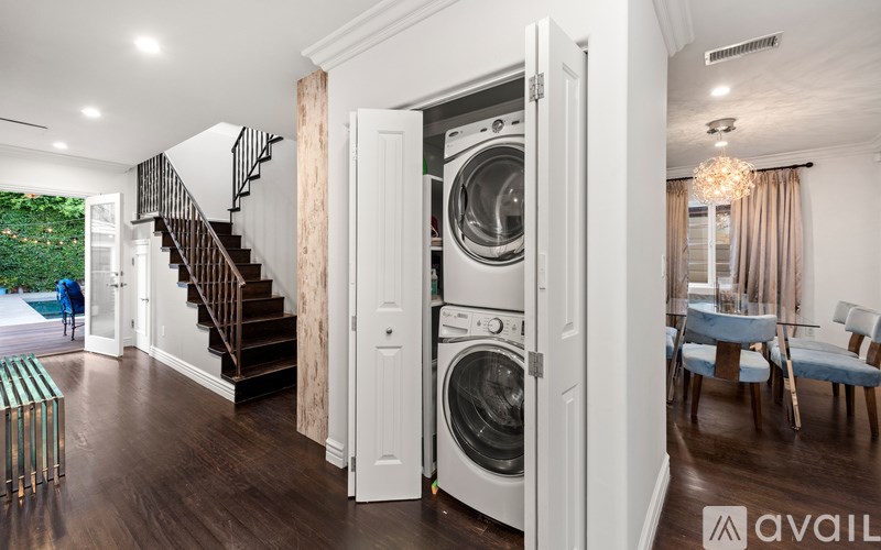 A modern laundry room with a washer and dryer built into the cabinetry.