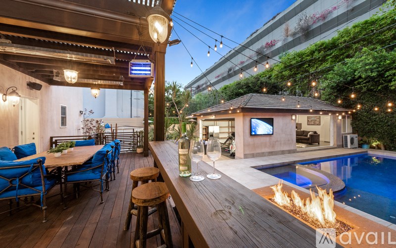 A modern outdoor living space with a pool and a bar area.