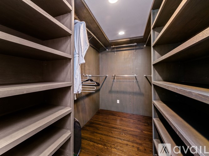 A walk-in closet with wooden shelves and a bench.