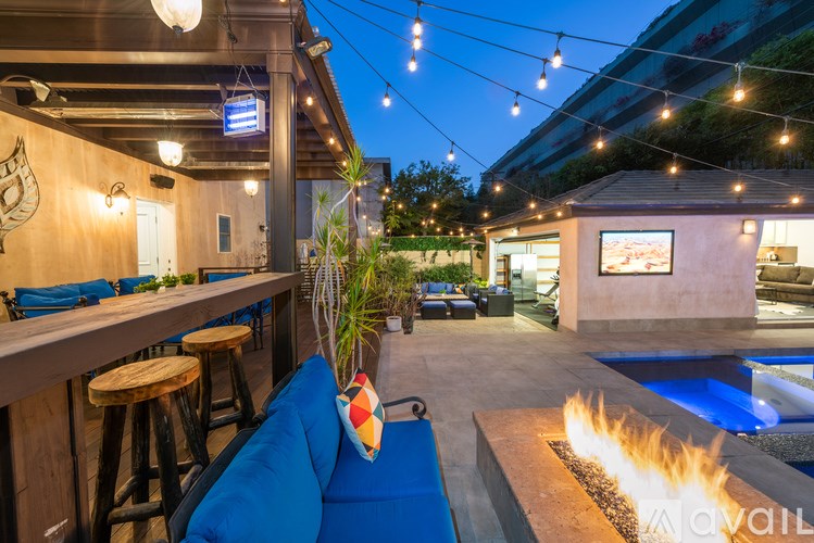 A bar with a blue couch and a fire pit.