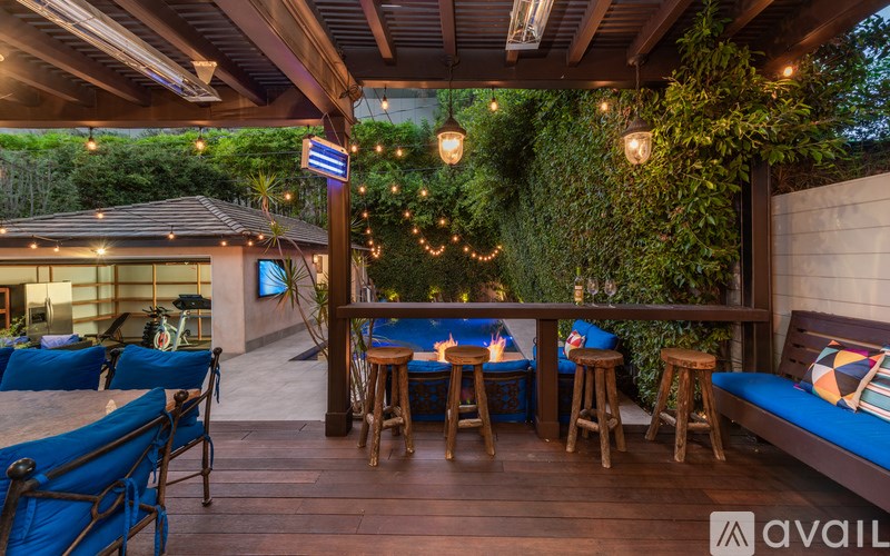 A wooden deck with blue chairs and a table with a sign that says "available" on it.