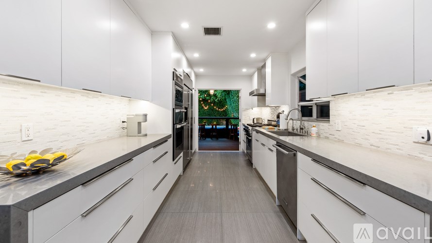 A modern kitchen with white cabinets and a long island.