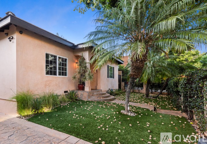 A house with a palm tree in front.