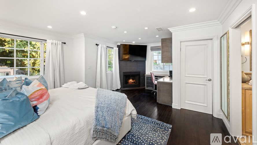 A bedroom with a large bed and a fireplace.