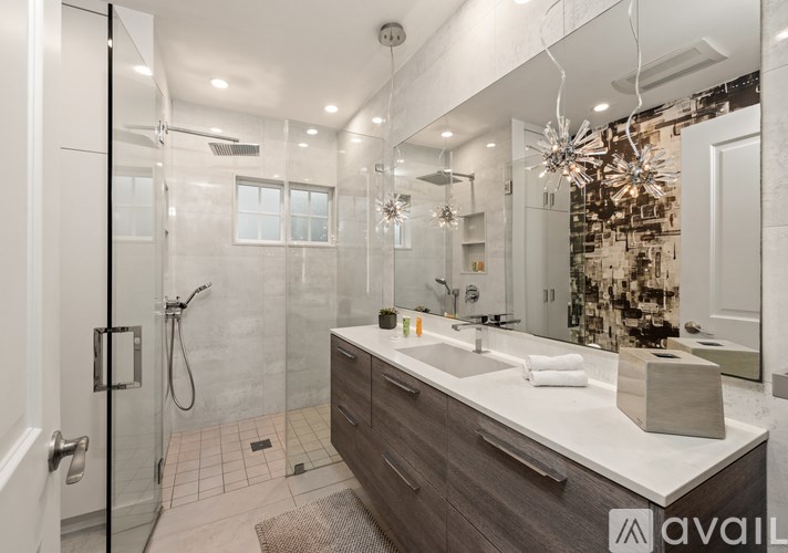 A modern bathroom with a walk-in shower and double sinks.