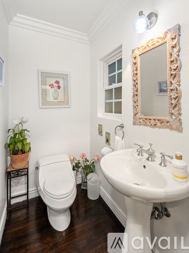 A bathroom with a white toilet, a white sink, and a mirror.