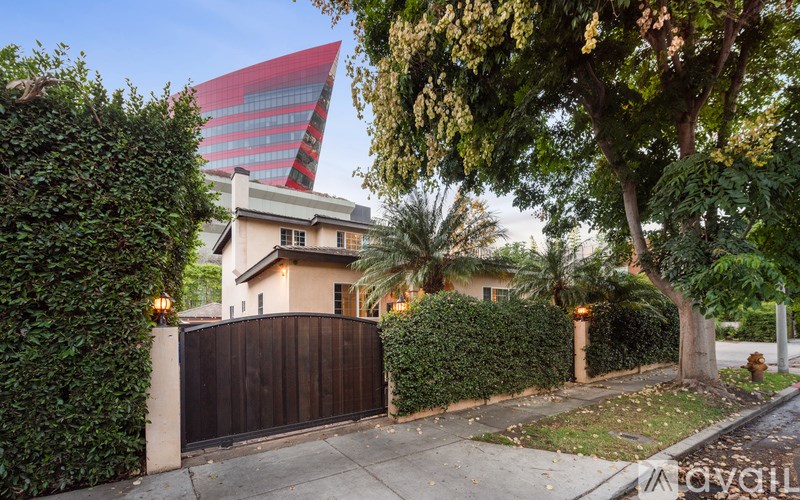 A house with a red and black building in the background.
