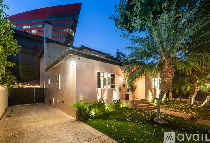 A house with a driveway and a palm tree in front.