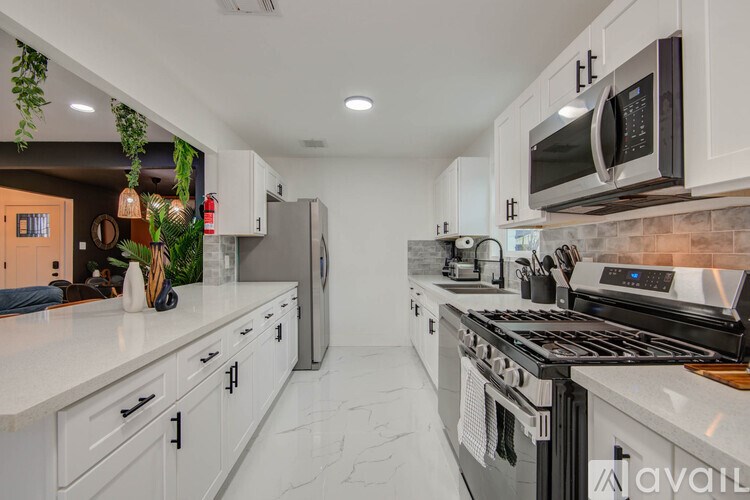 A kitchen with white cabinets and a black stove top oven.