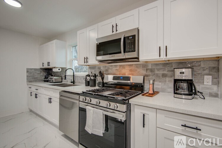 A kitchen with white cabinets and a black stove top.