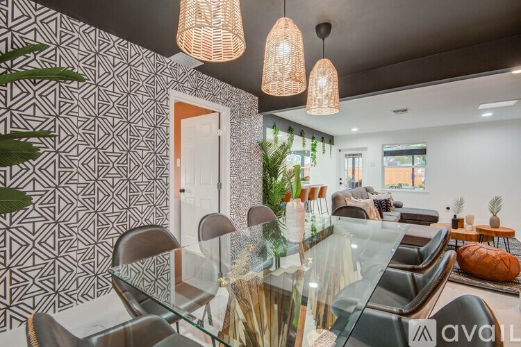 A modern dining room with a glass table and chairs.
