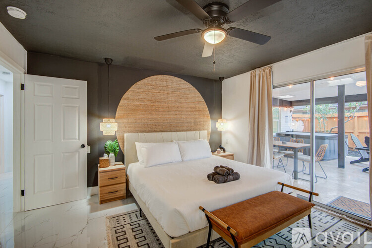 A bedroom with a large bed and a ceiling fan.