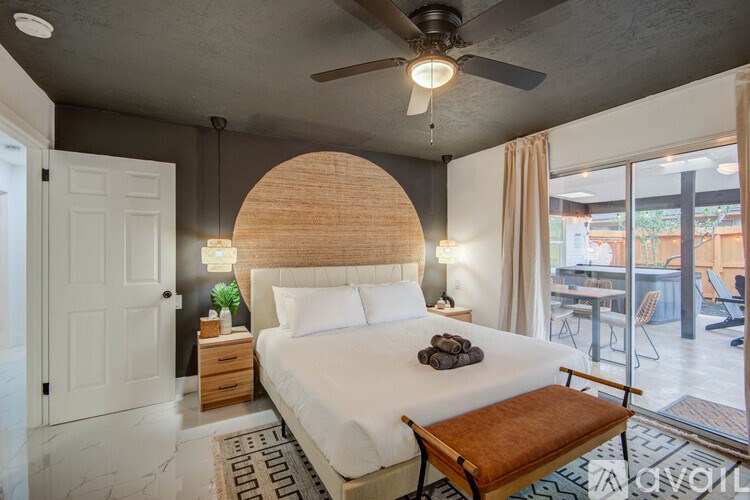 A bedroom with a large bed and a ceiling fan.