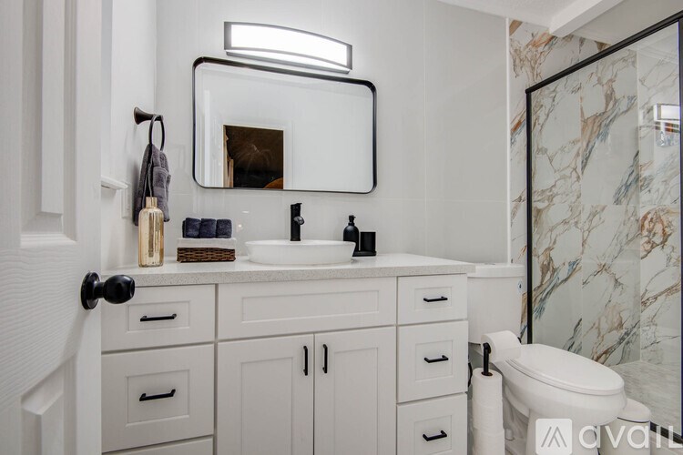 A bathroom with a marble wallpaper and a white sink.