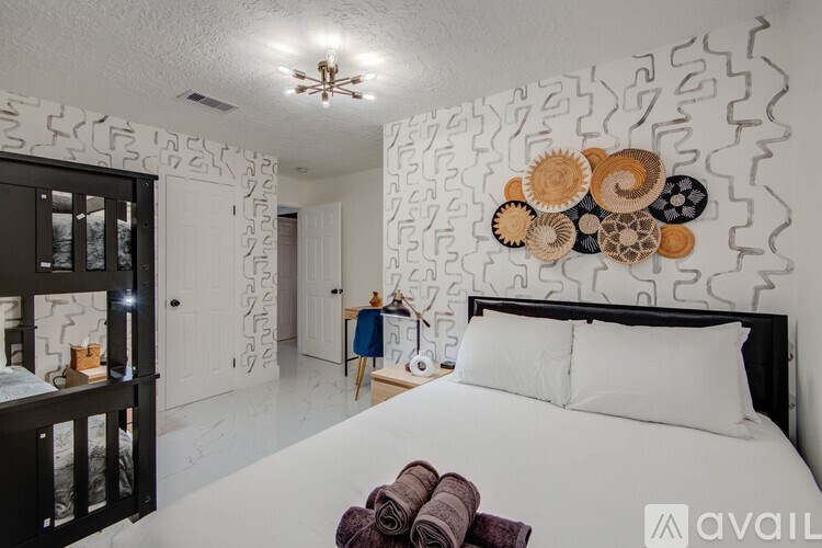 A bedroom with a large bed and a wall decoration of circular patterns.