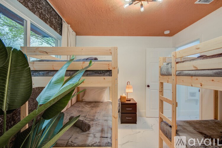 A room with bunk beds and a wooden nightstand.