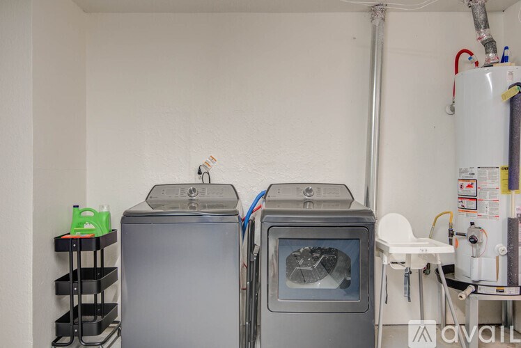 A room with two ovens and a white chair.