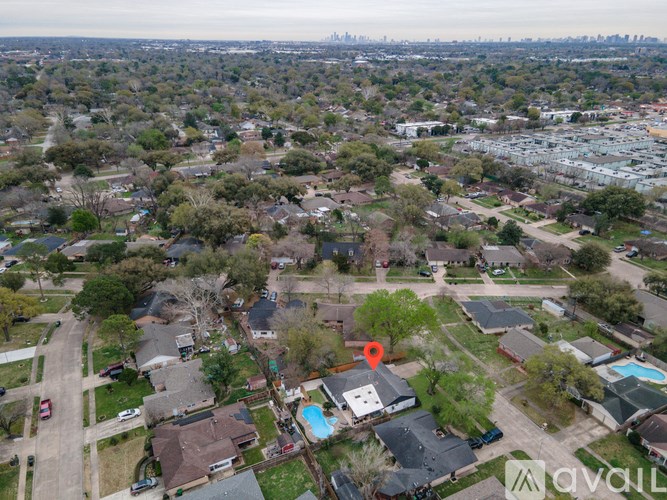 An aerial view of a neighborhood with a red marker indicating a specific location.