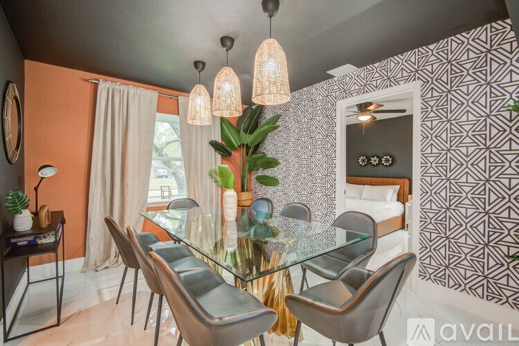 A modern dining room with a glass table and chairs.