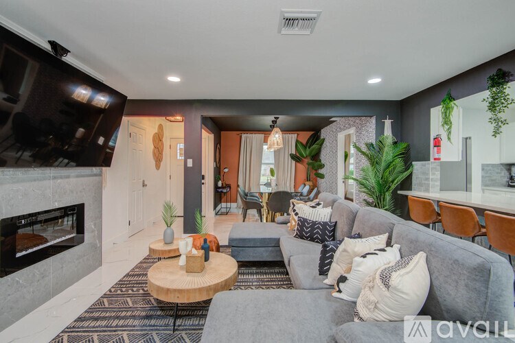A living room with a grey couch and a fireplace.