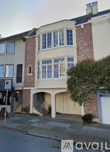 A two-story building with a brick chimney and a balcony.