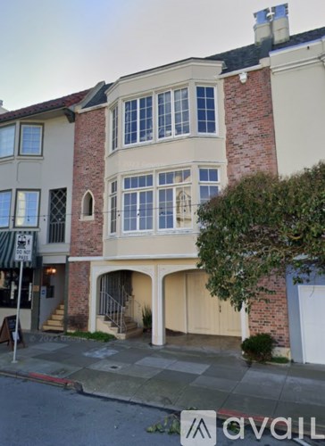 A two-story building with a brick chimney and a balcony.