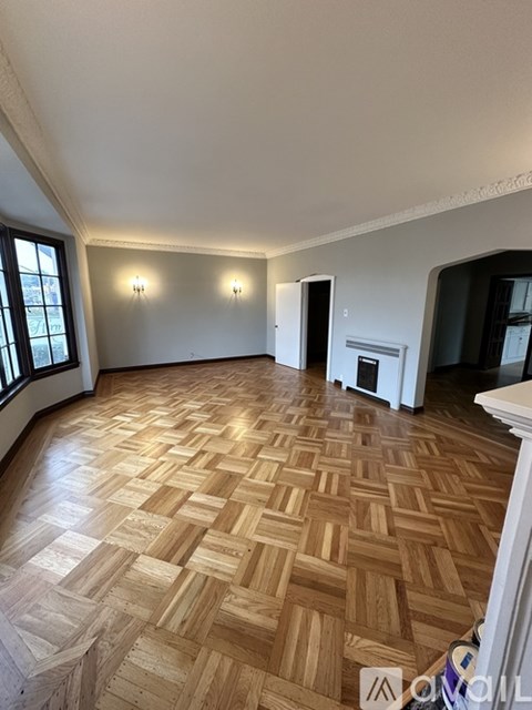 A room with wooden flooring and white walls.