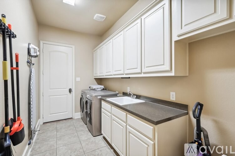 A kitchen with white cabinets and a washing machine.