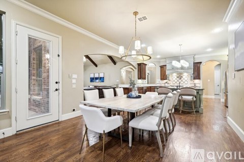 A dining room with a white table and chairs.