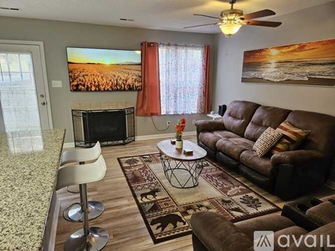 A living room with a fireplace and a television mounted above it.
