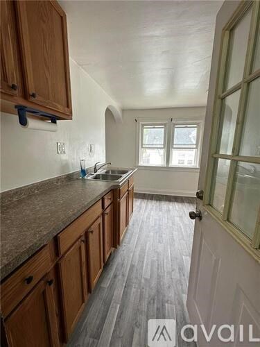 A kitchen with wooden cabinets and a granite countertop.