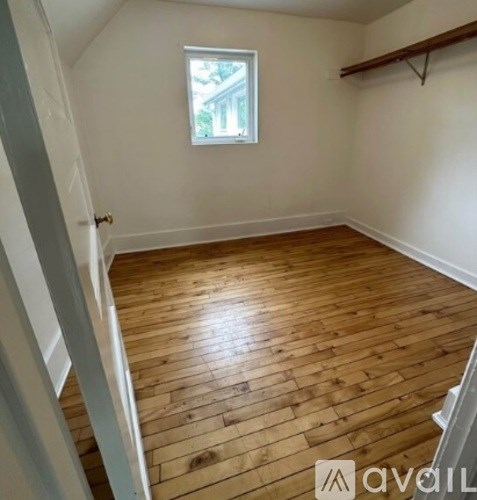 A room with wooden flooring and a window.