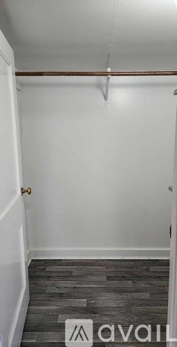 A room with a wooden floor and a white wall.