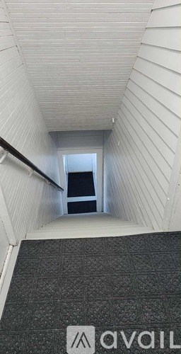 A long hallway with wood floors and white walls.