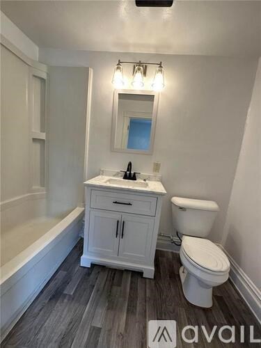 A bathroom with a toilet, sink, and bathtub.