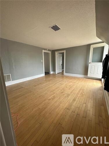 A room with wooden flooring and a ceiling fan.